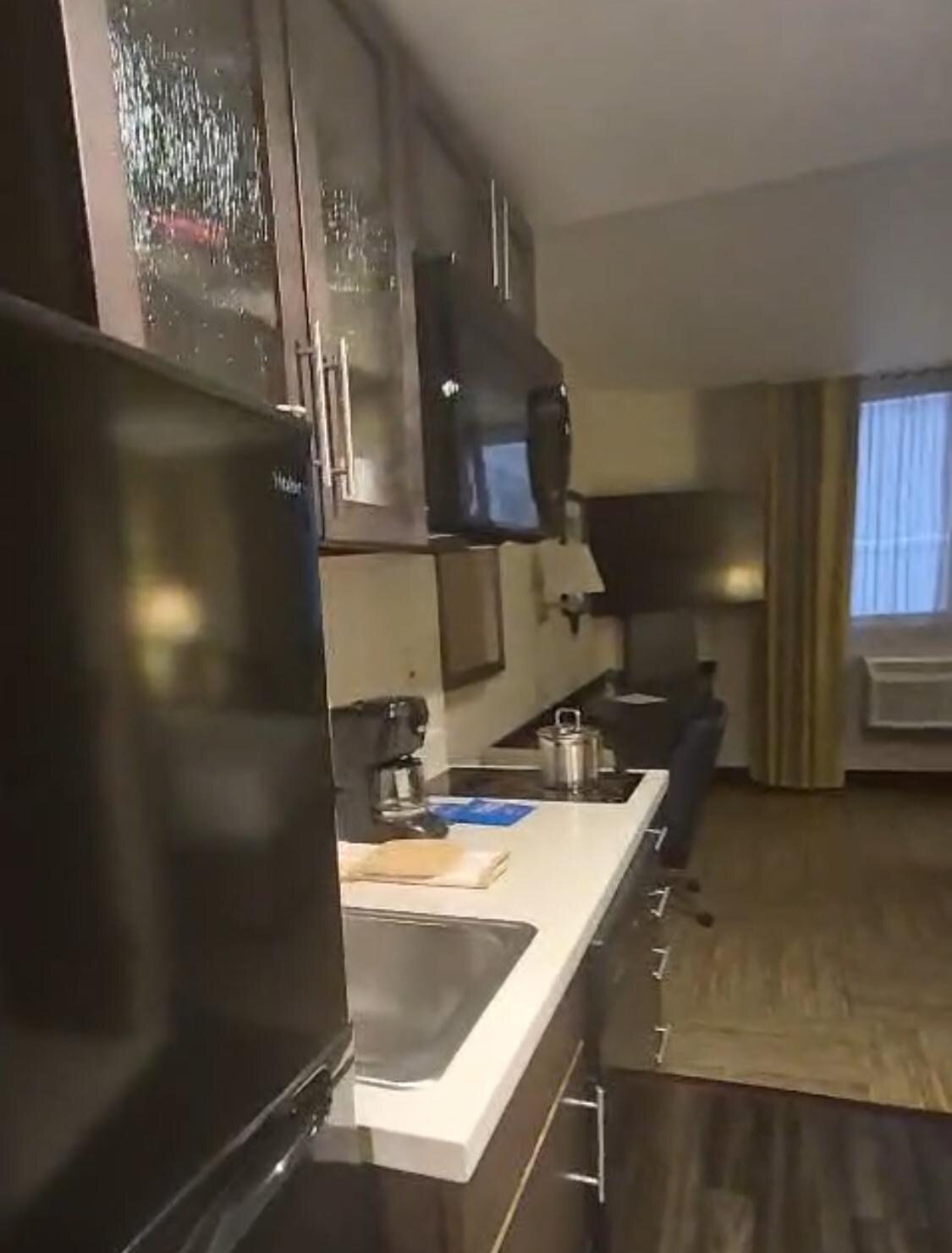 Cocina con refrigerador, horno de microondas, cafetera, utensilios de cocina