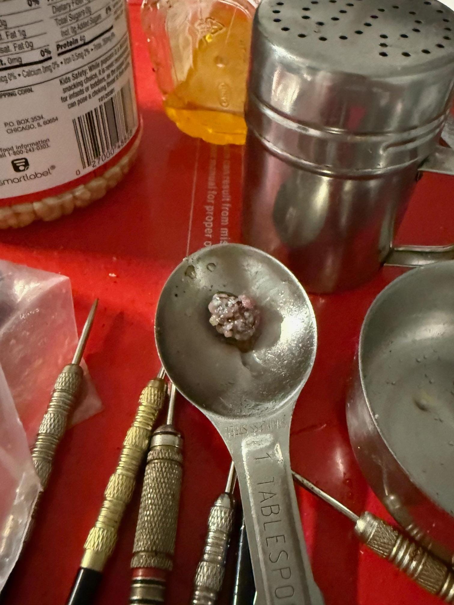 This is the top of the filthy popcorn machine in the movie theater.  Something was growing in the dirty measuring spoon with all the darts for the dart board.