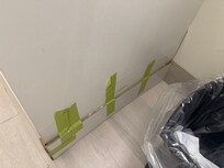 Painters, tape holding on the baseboard