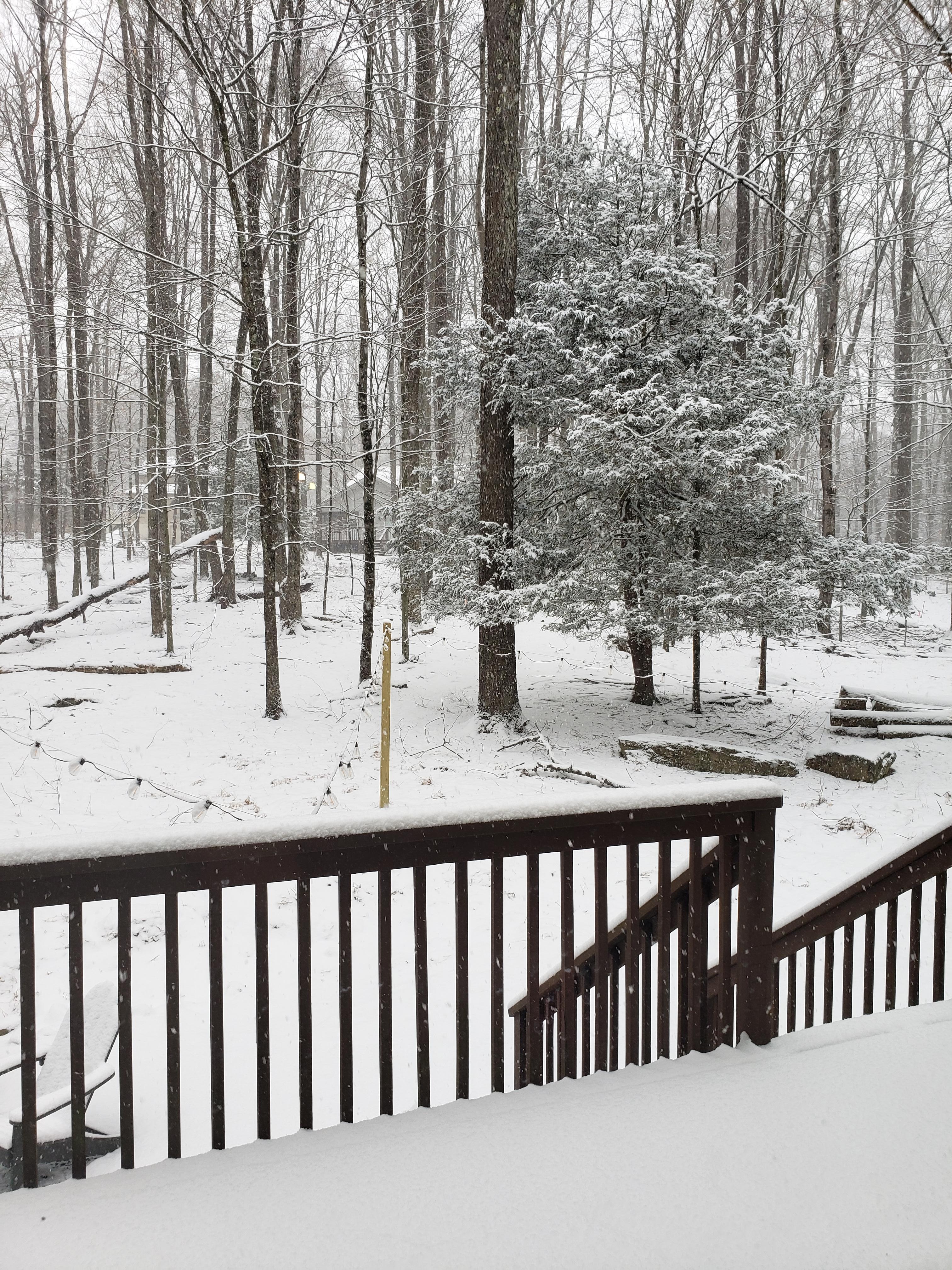 View from the dining room door out to the deck and fire pit area after snow