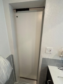 Porte de salle de bains sans poignée, mal ajustée en hauteur et sur son rail