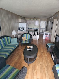 Condo living room & kitchen in back of pic