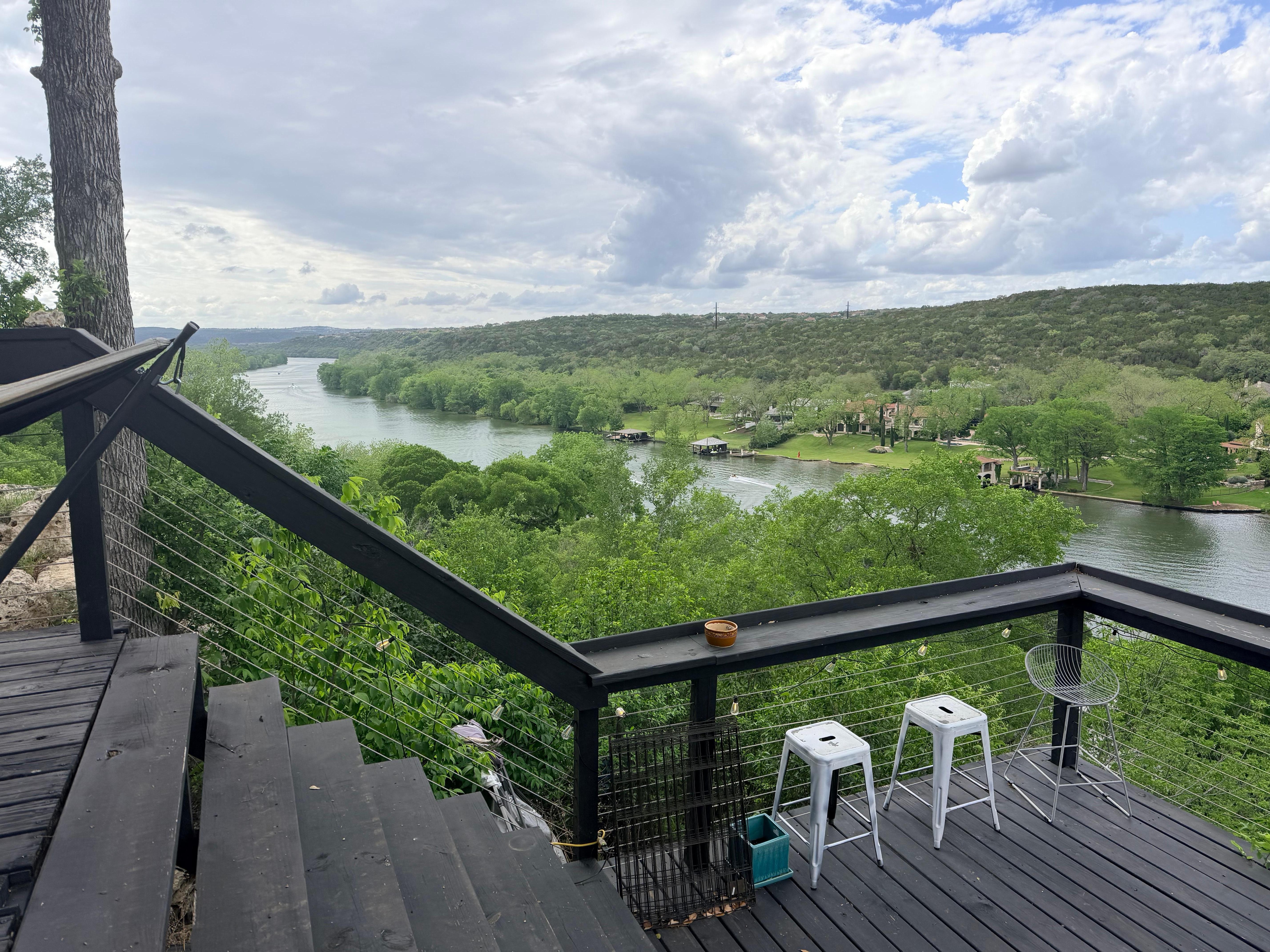 View of the river with trash in the trees on the other side of the railing
