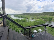 View of the river with trash in the trees on the other side of the railing