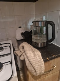 Dirty jug with limescale with a random cardigan left on the counter