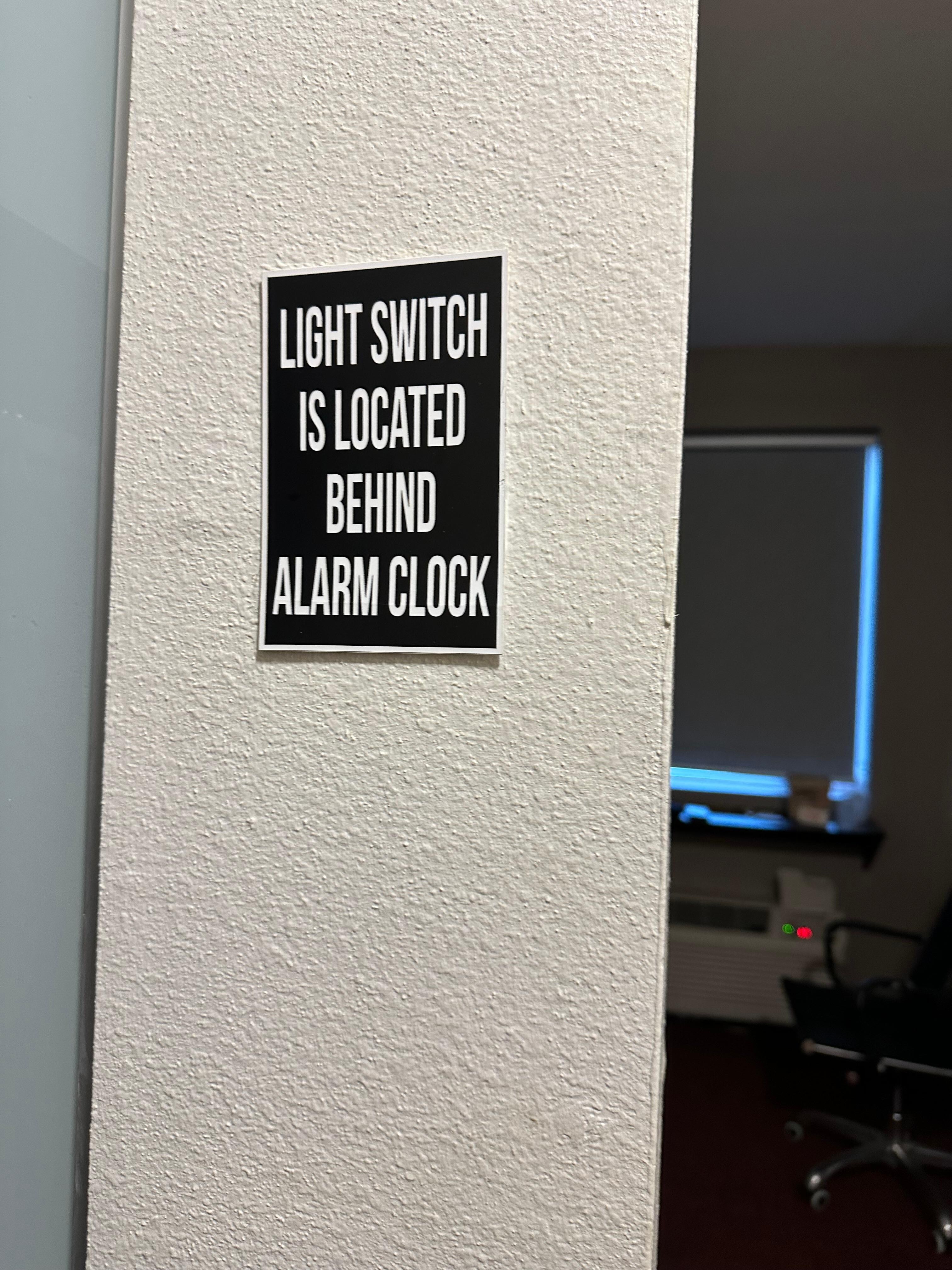 Sign advising where bedroom light switch was on wall next to closet 