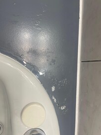 Sink counter was painted over, with paint coming off.