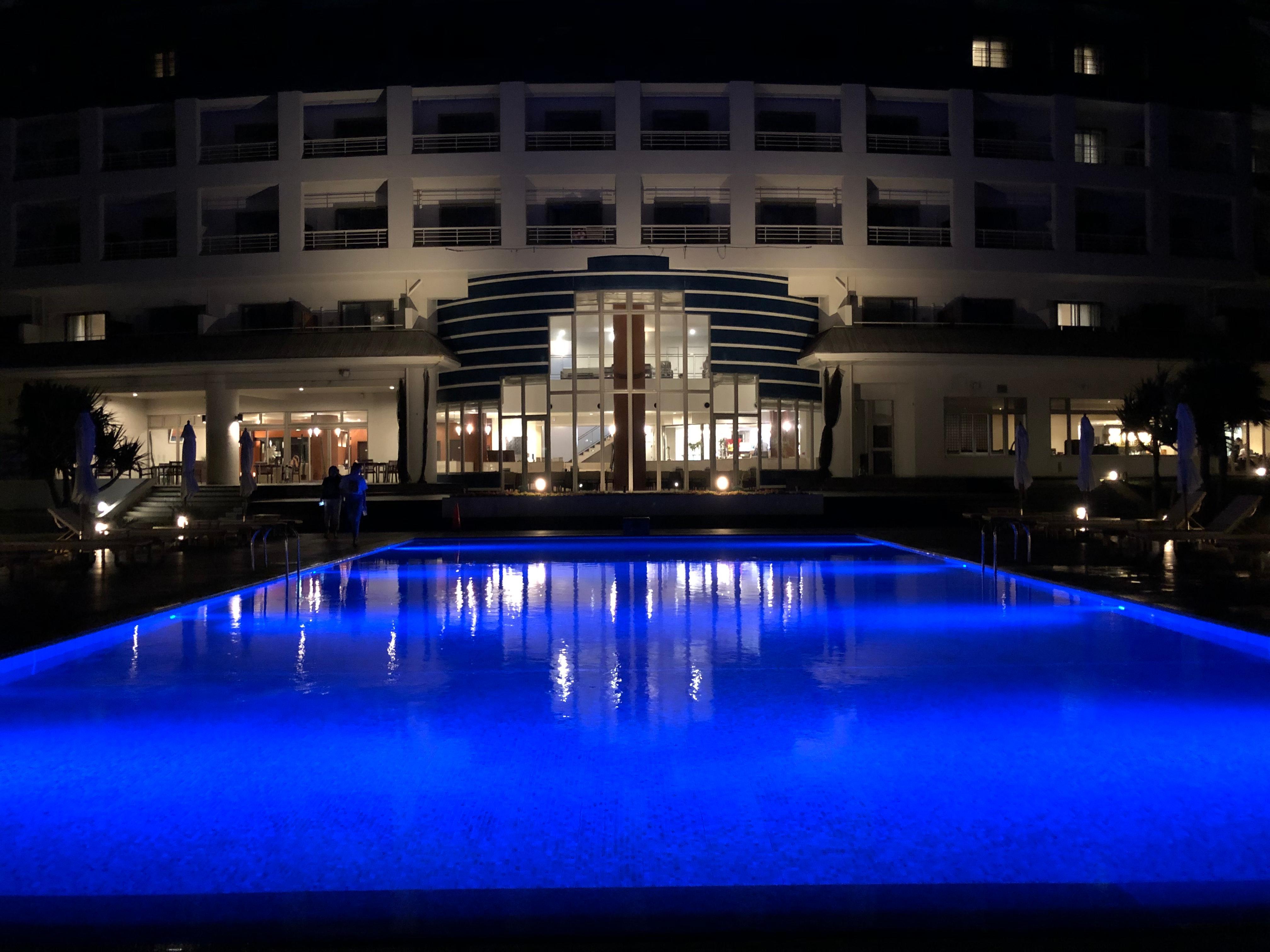 Hotel pool side, evening. 