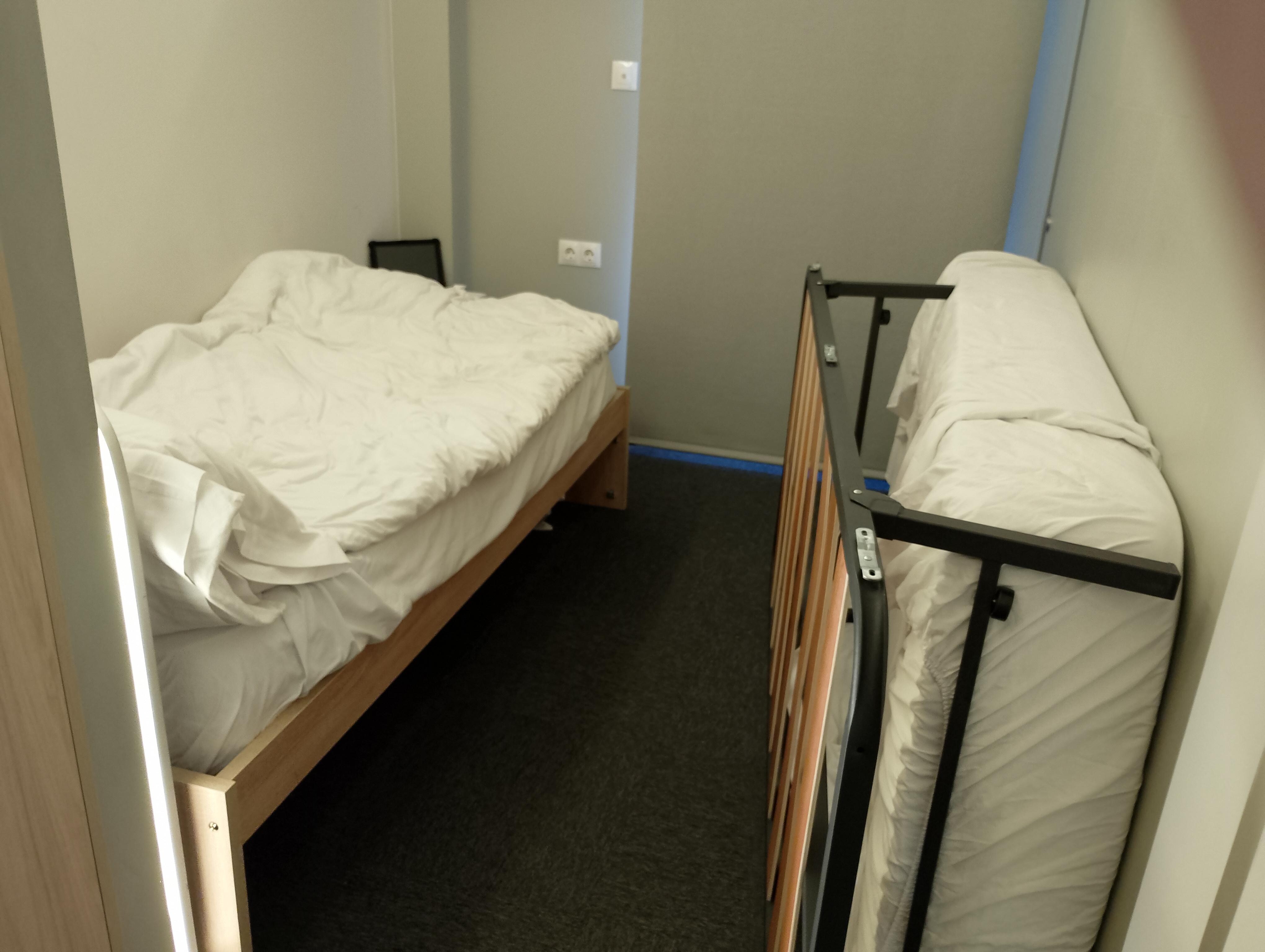 Half of the bed propped against the wall creating space
