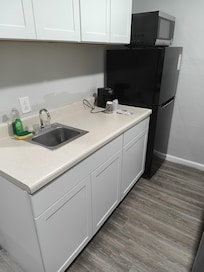 Kitchen area with appropriately-sized refrigerator/freezer, and microwave.