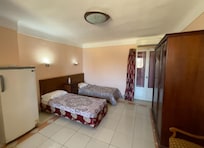 My hotel room showing the fridge on left and AC up right and the door to the tiny balcony view to backside of old buildings