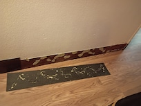 Trim off the wall. I tried to stick it back on wall and it kept falling off. And the floor was dirty on that side of the bed.