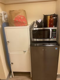 Microwave and fridge and locked cabinet where the closet should have been