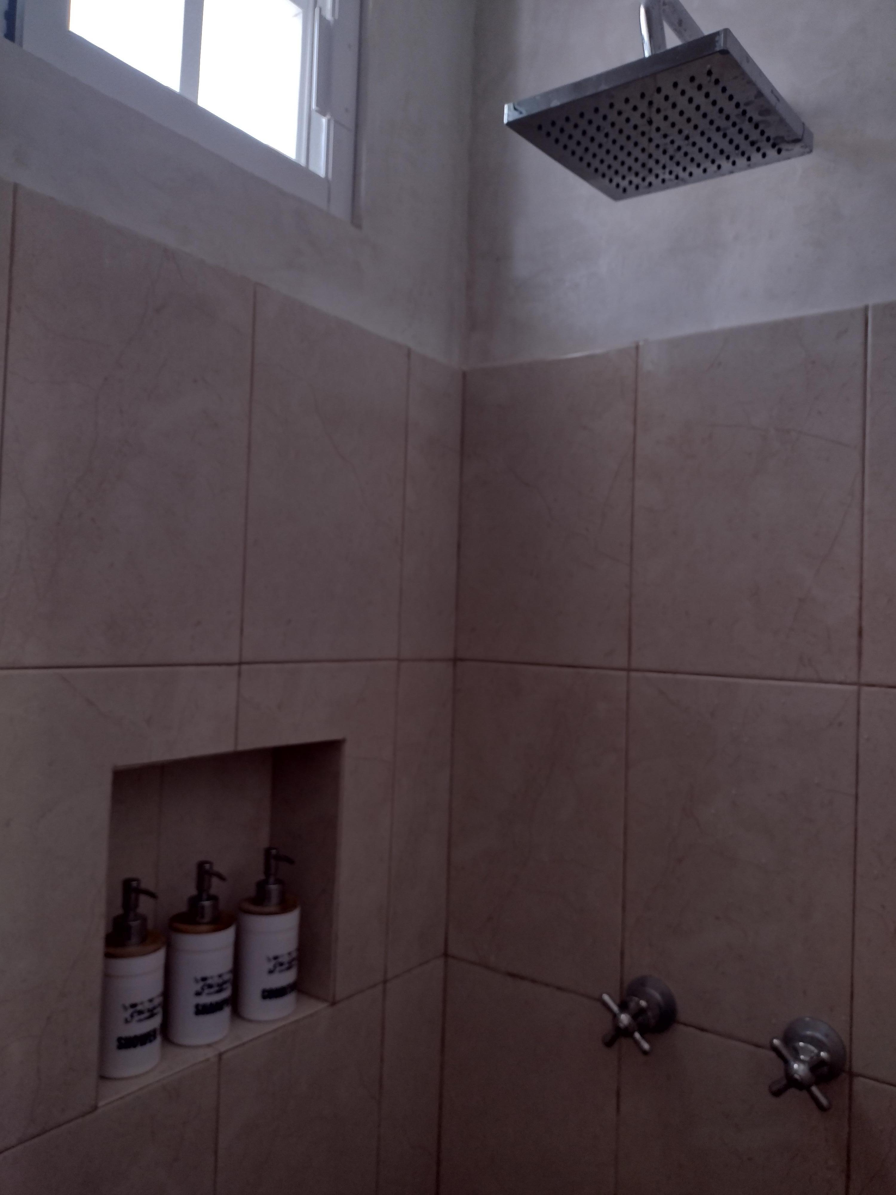 Shower with rainwater showerhead and toiletries