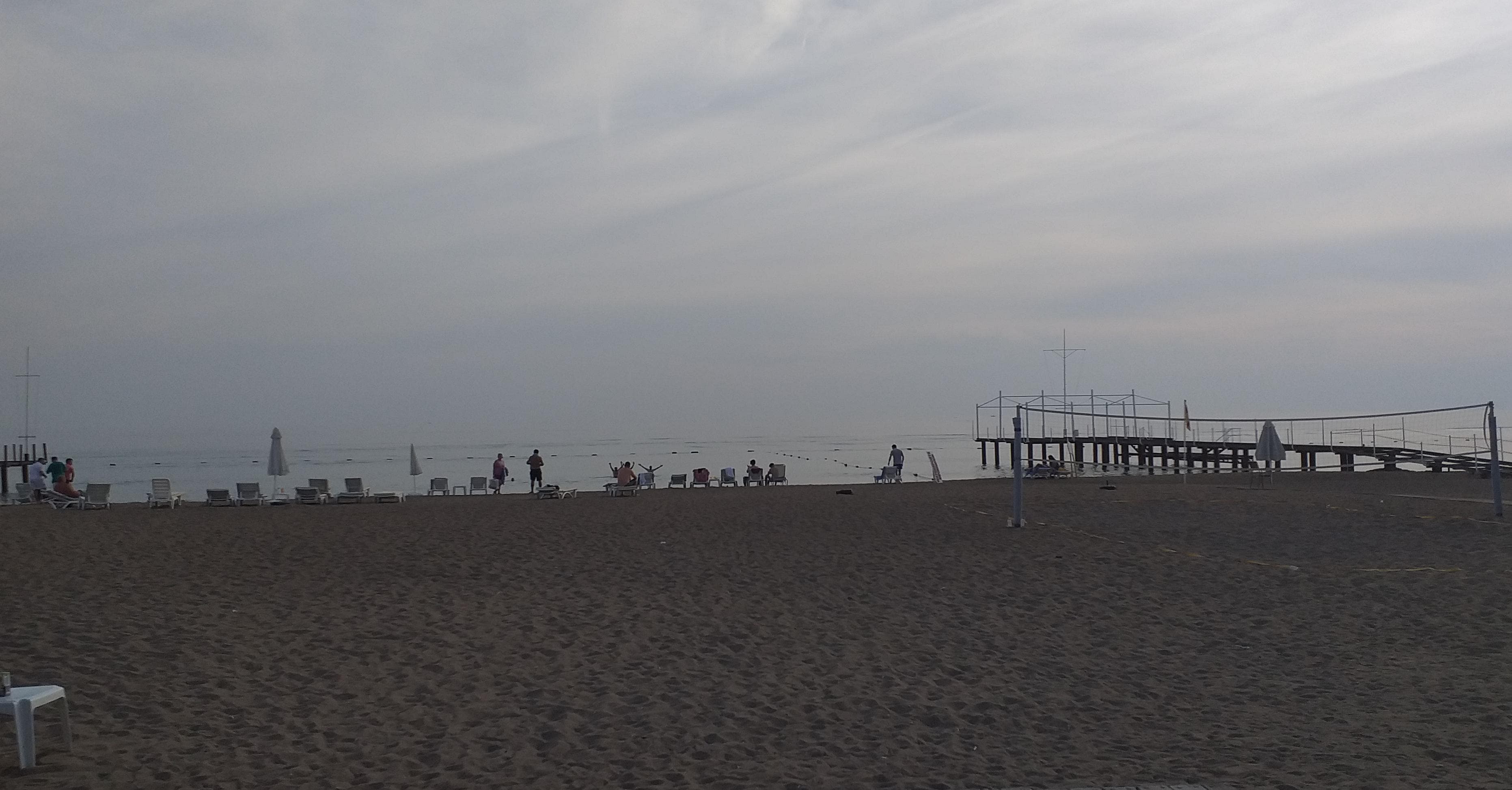 View of the spacious private beach with sunchairs and beach volleyball.