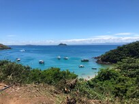 Praia João Fernandinho vista da rua. Acesso por escadaria à direita.