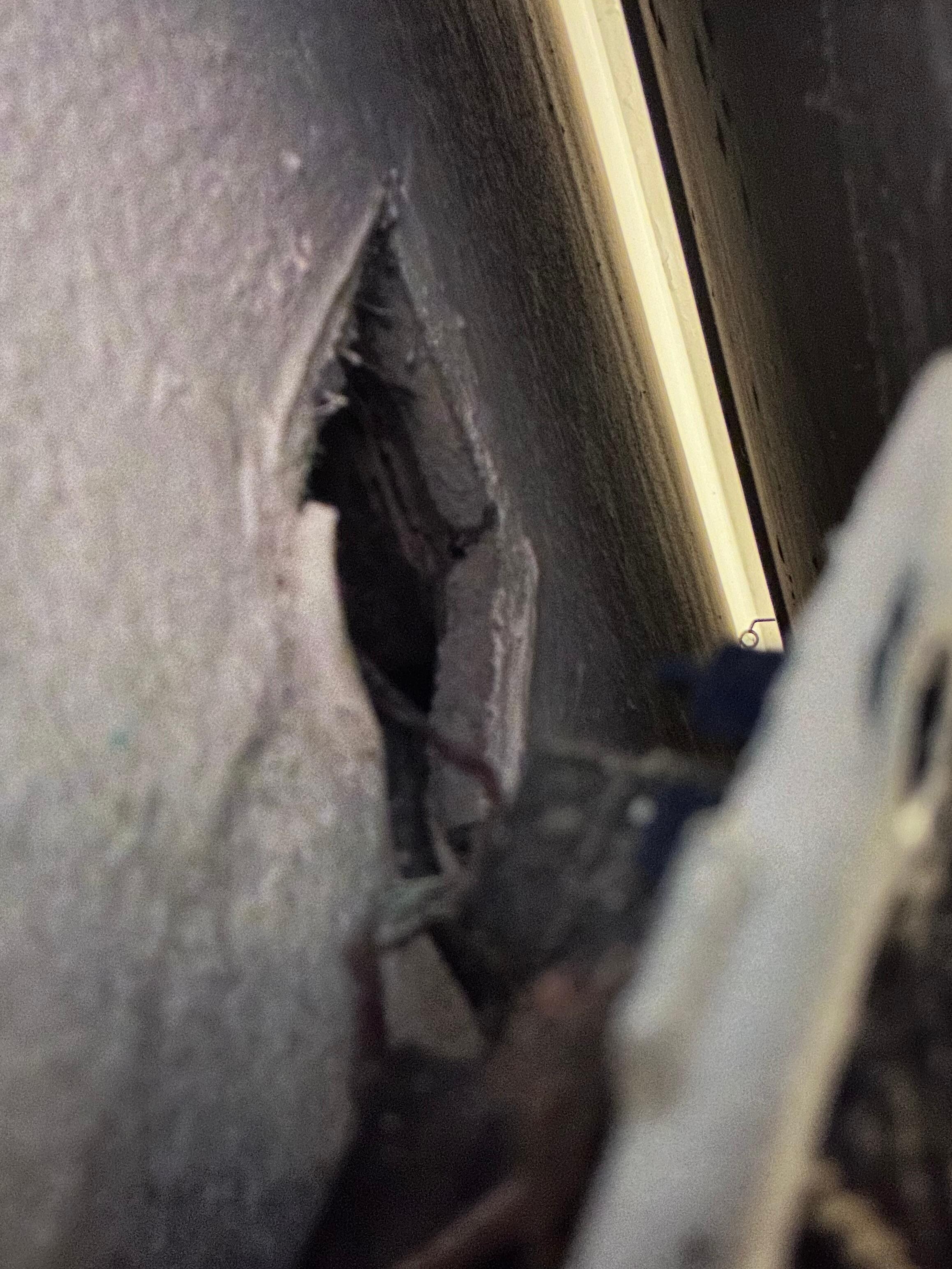 Outlet behind bed with exposed wires. Only outlet available for one half of room. Unsafe!