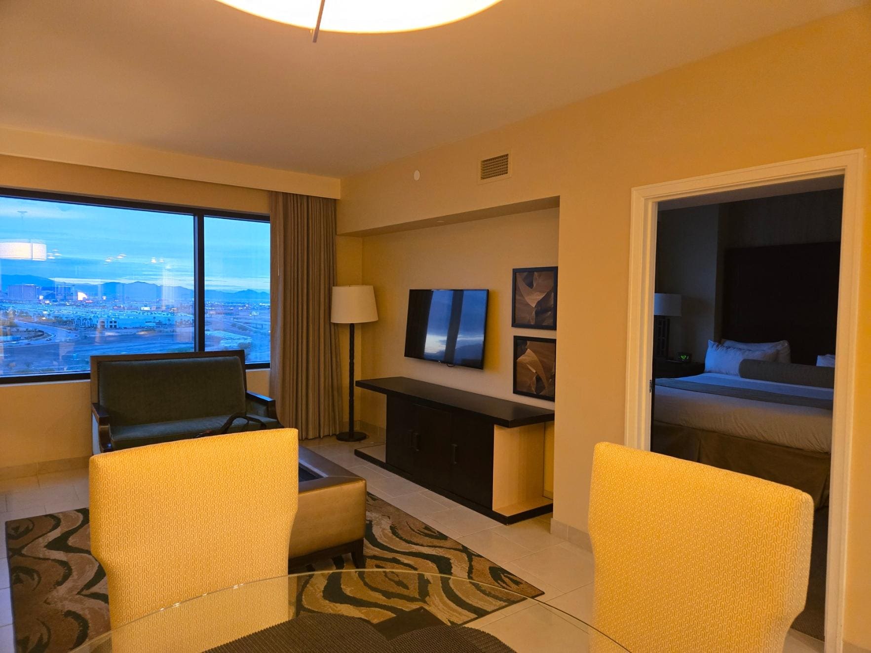 View from the entrance door. You can see the bedroom to the right. Kitchen was to the left. The pull out couch is not visible but is on the left side wall. You can see the glass dining table in the bottom left of the photo.