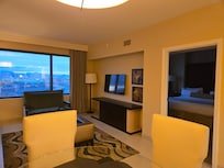 View from the entrance door. You can see the bedroom to the right. Kitchen was to the left. The pull out couch is not visible but is on the left side wall. You can see the glass dining table in the bottom left of the photo.