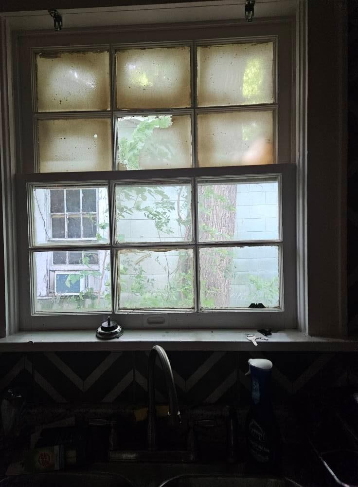 Full view of kitchen window; filthy, no curtains, & awful neighborhood