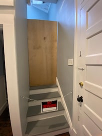 “Separate unit” behind playwood board across stairwell in house behind kitchen.