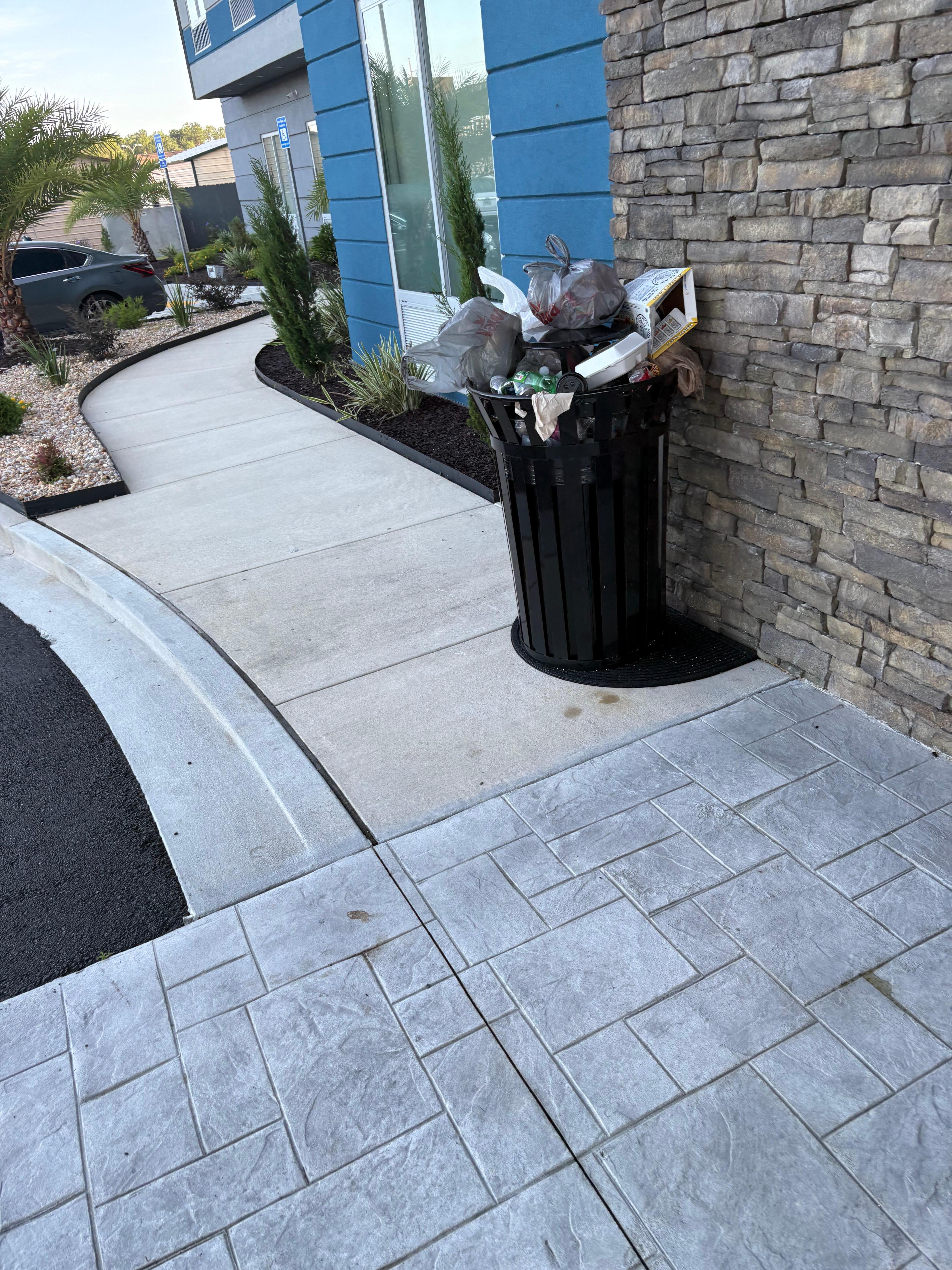 Trash bins overflowing near front entrance 