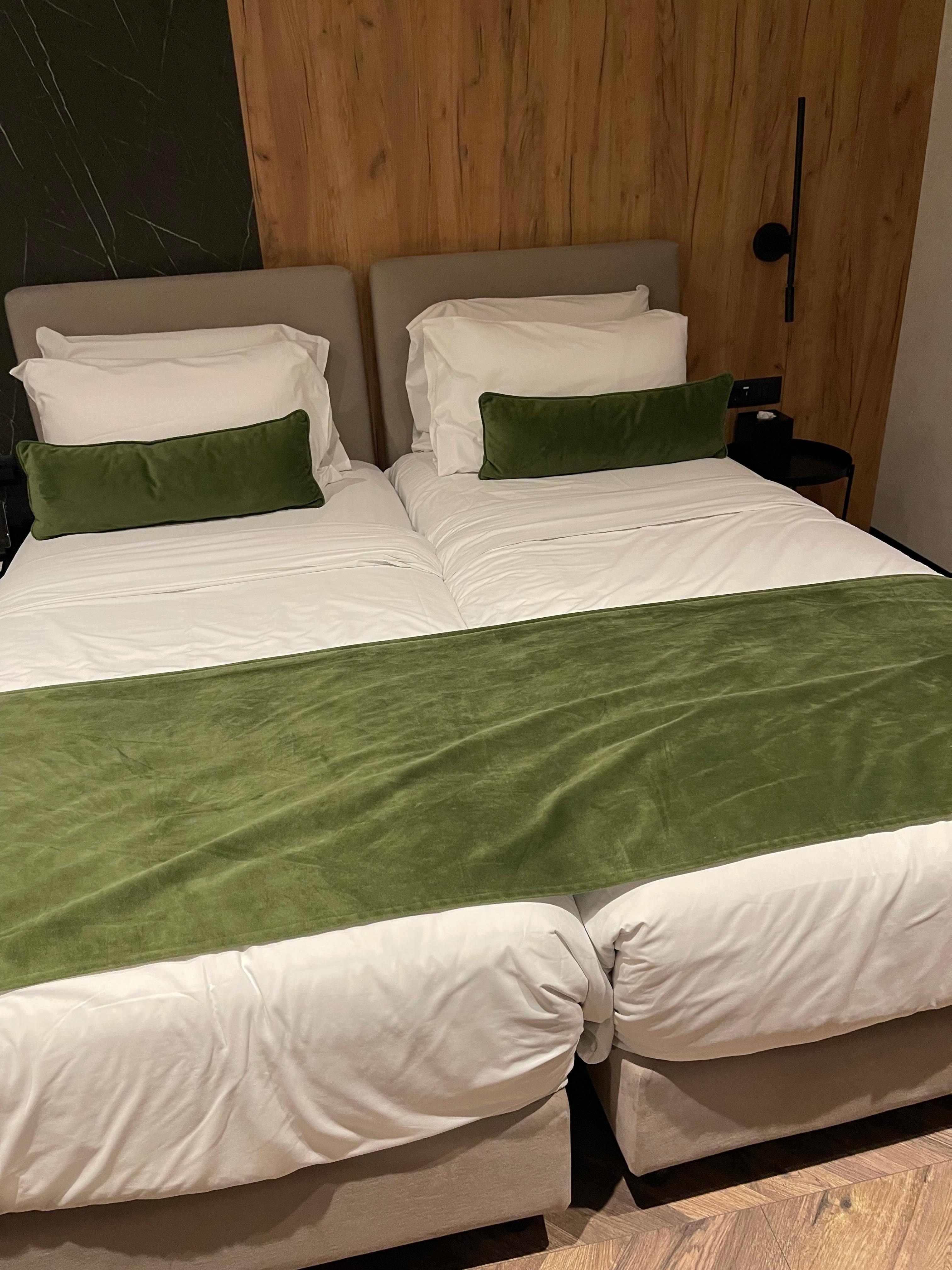 Clean white sheets with wrapped in blanket topped with green velvet 