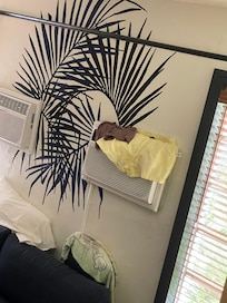 Shared hostel room where someone hangs their wet clothes from AC unit blocking air flow.