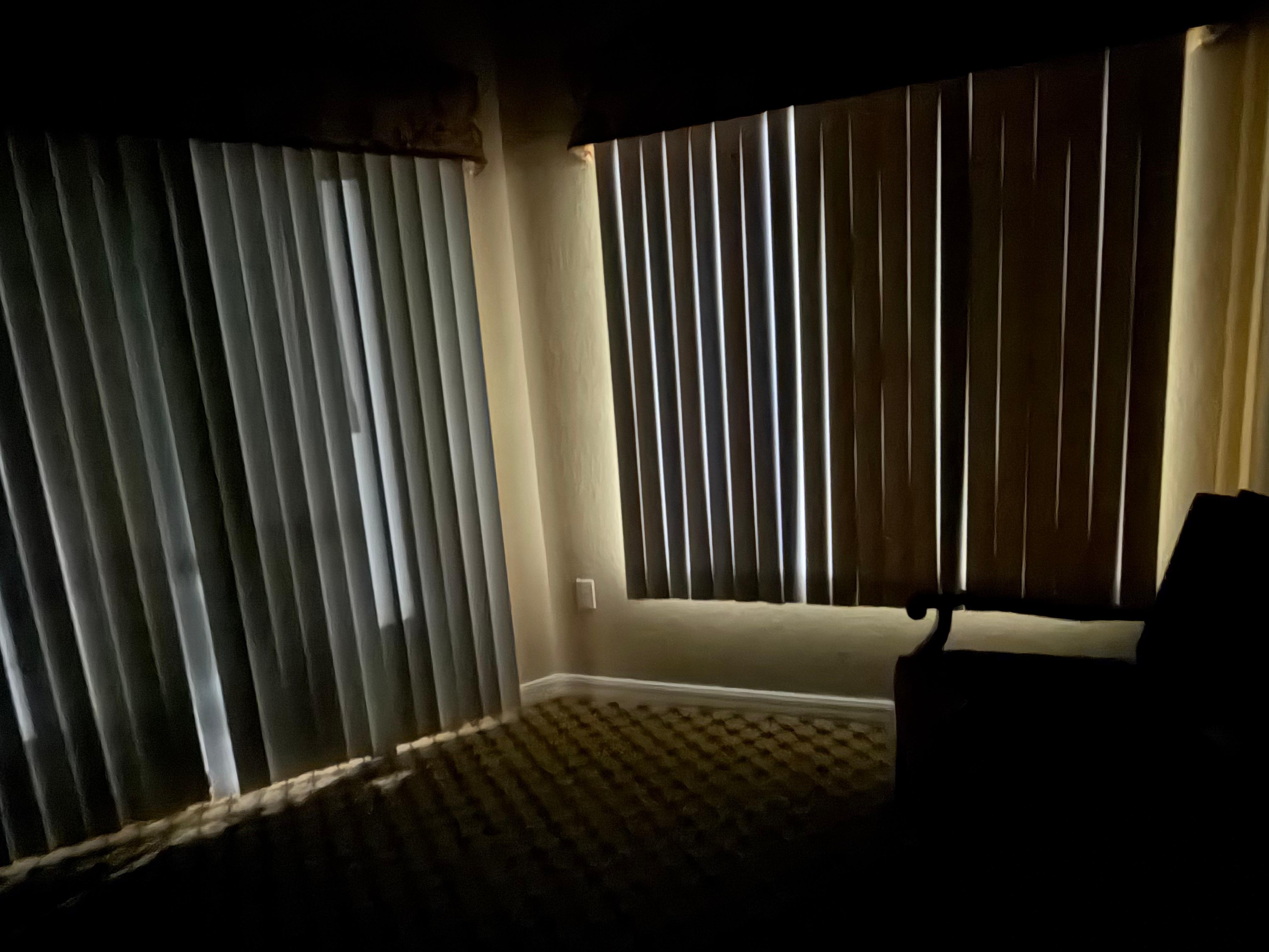 The lights from outside shinning through the blinds 