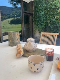 Petit dej idyllique sur la terrasse face au chèvrefeuille et au pâturage
