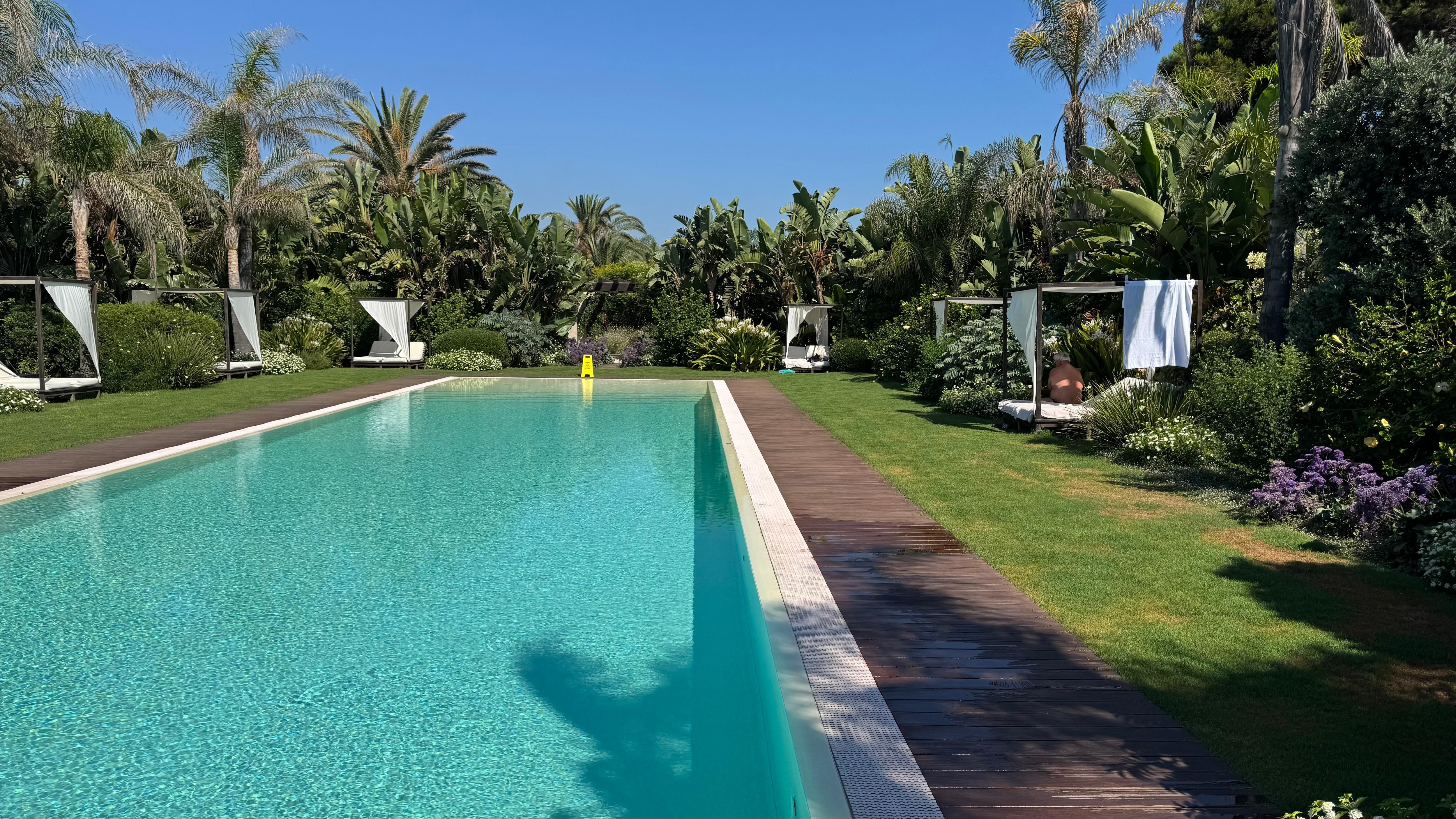 rechteckiger Pool zwischen Garten und Restaurant