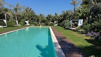 rechteckiger Pool zwischen Garten und Restaurant