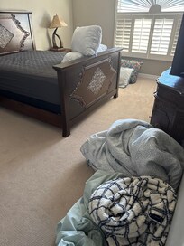 Another bedroom with dirty linens on the floor