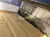 Rusted garage door and stained driveway