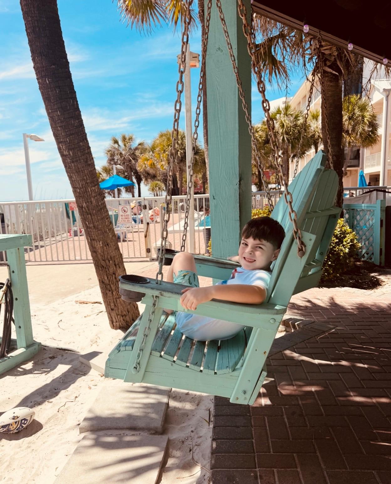 My 7 year old living his best life on the swings at the resort that face the ocean 