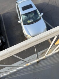 Phot of car broken down outside our room with pill bottles and trash piled up in it. Whole place has cars broken down on it