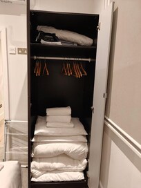 Small Wardrobe with spare linens made it difficult to hang clothes.