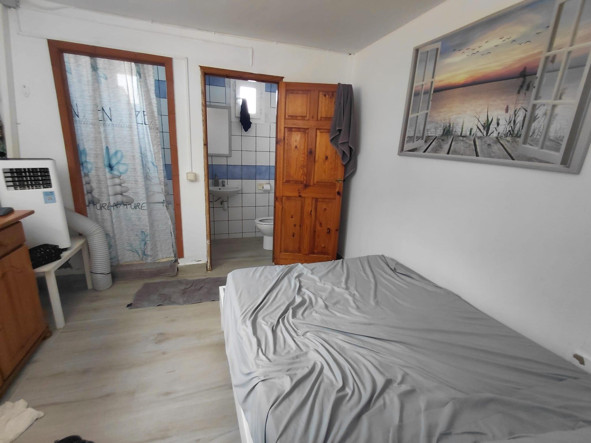 Basement Bedroom. Air con pipe had to make its way out of the curtained cubicle on the left!