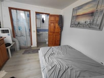 Basement Bedroom. Air con pipe had to make its way out of the curtained cubicle on the left!