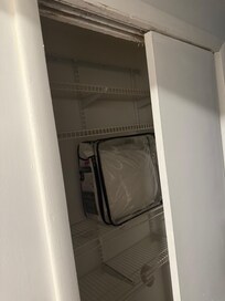 Closet with card saying be careful door could fall off