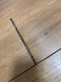 Gaps in flooring with junk in cracks