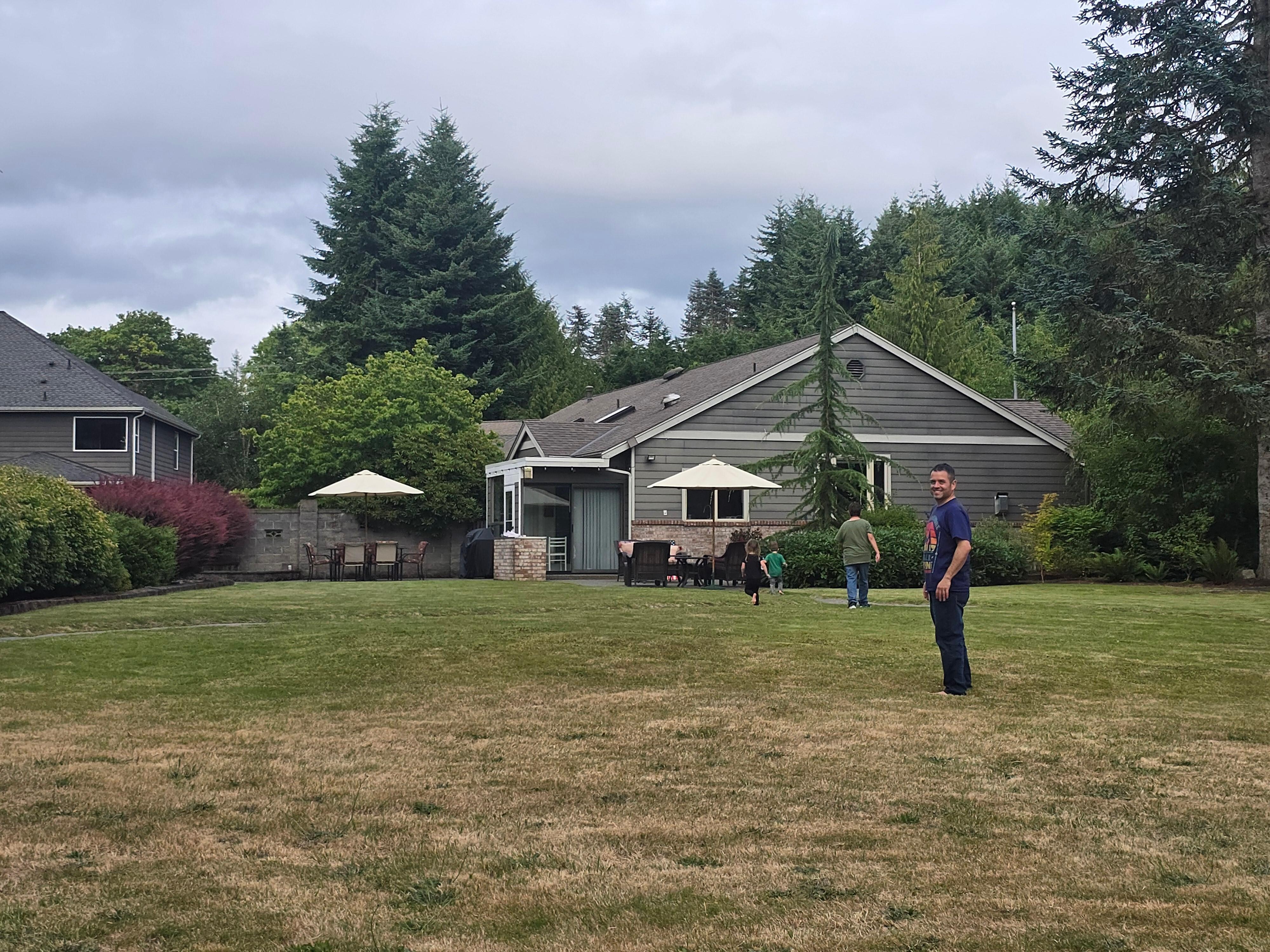 In the backyard facing the back of the house and patio area.