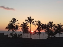 Sunset at the bottom of the heart formed by the palm trees