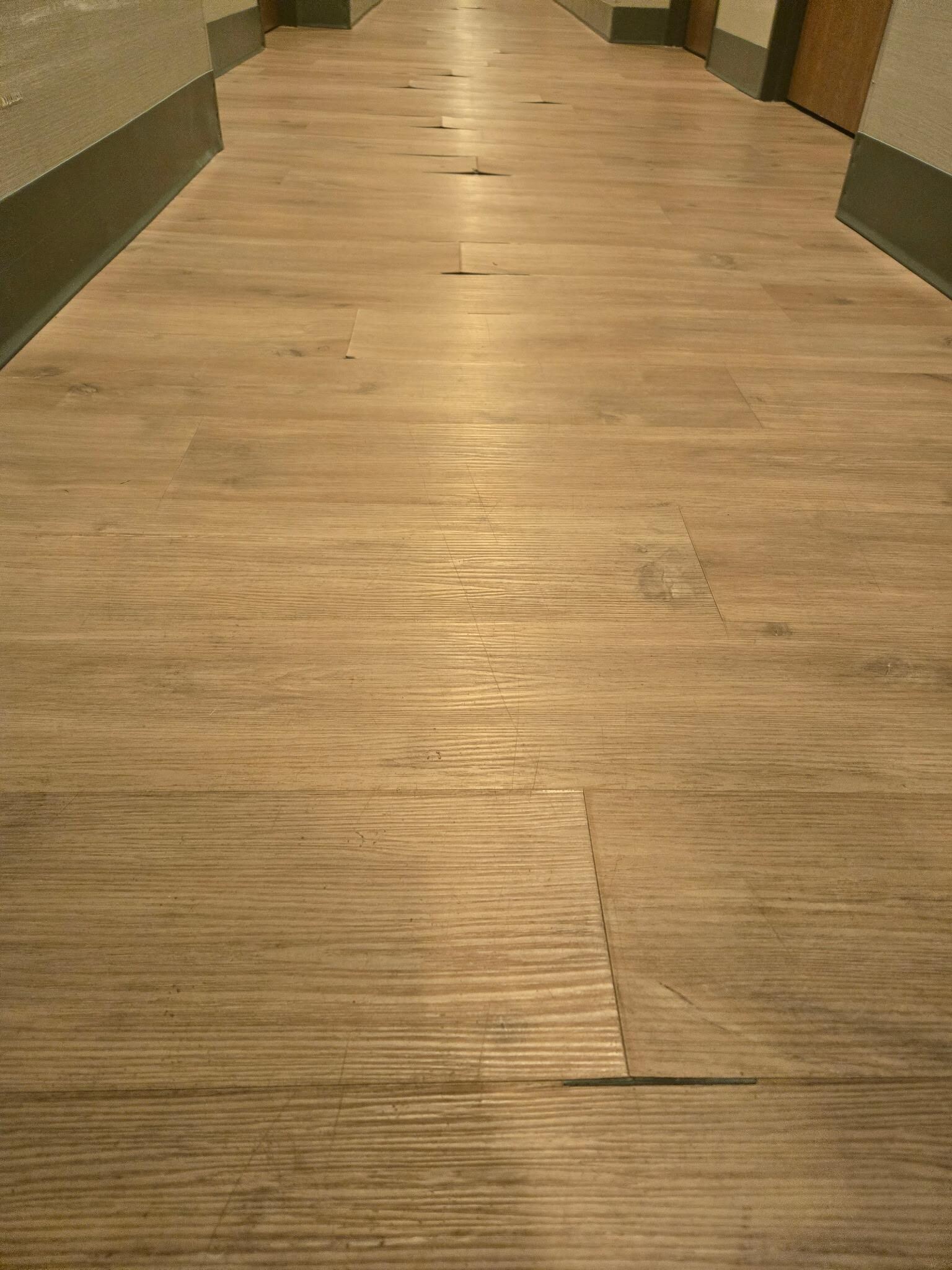 The laminate flooring raveling throughout the hallway.