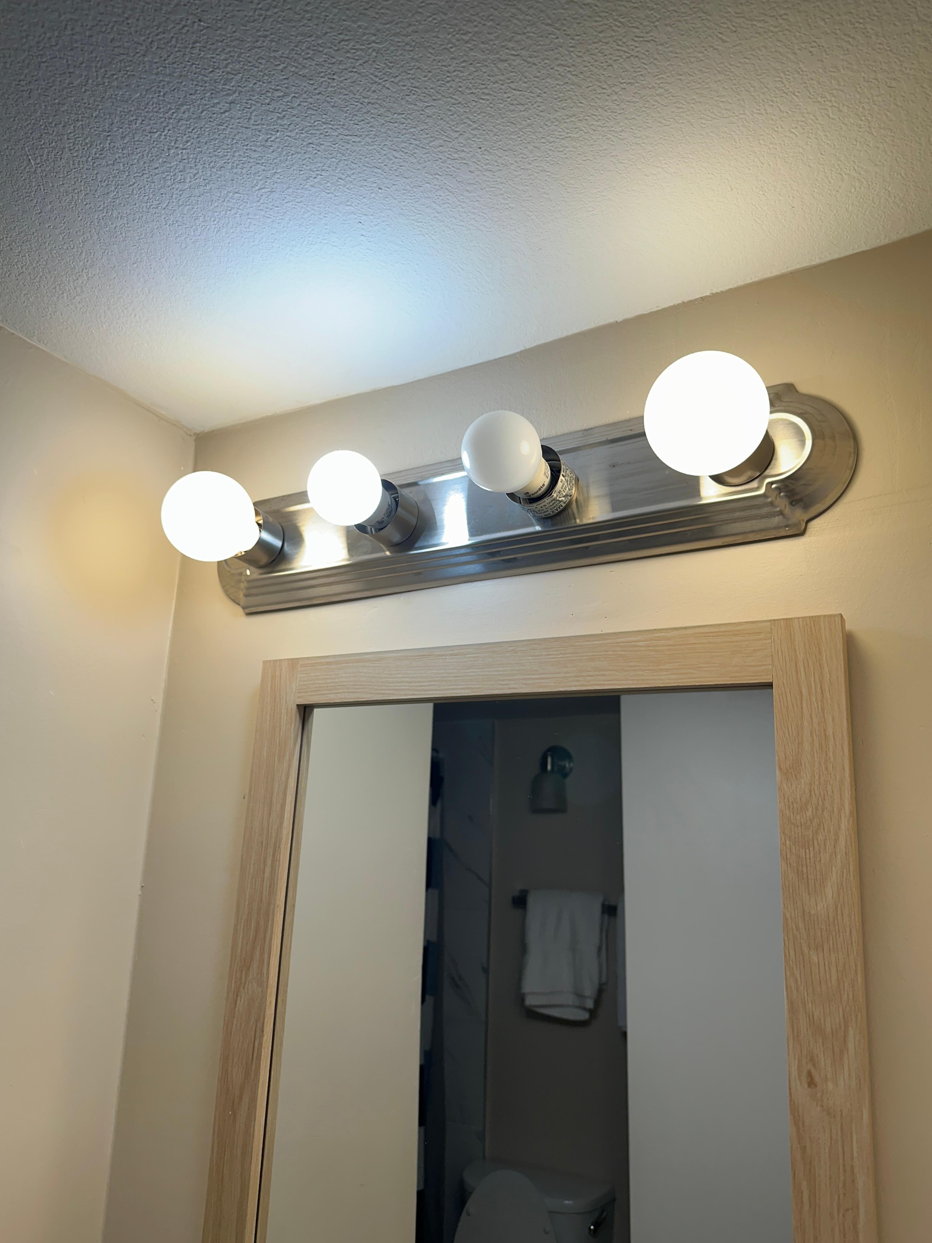 In the bathroom, the vanity light fixture was designed for four bulbs. One bulb was missing, and another was a different size and color than the others.