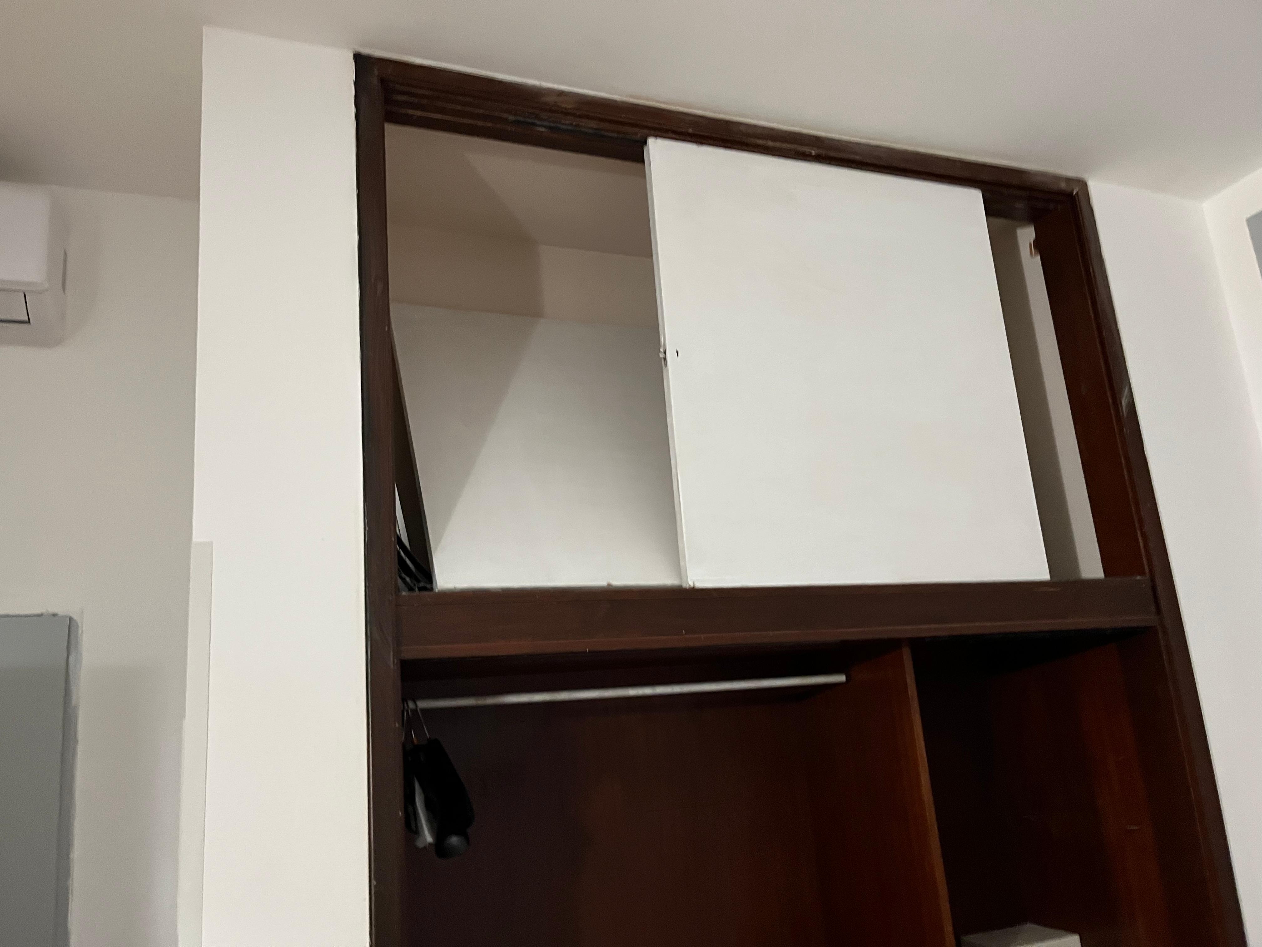 The closet with the upper doors broken, the lower doors missing.