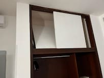 The closet with the upper doors broken, the lower doors missing.