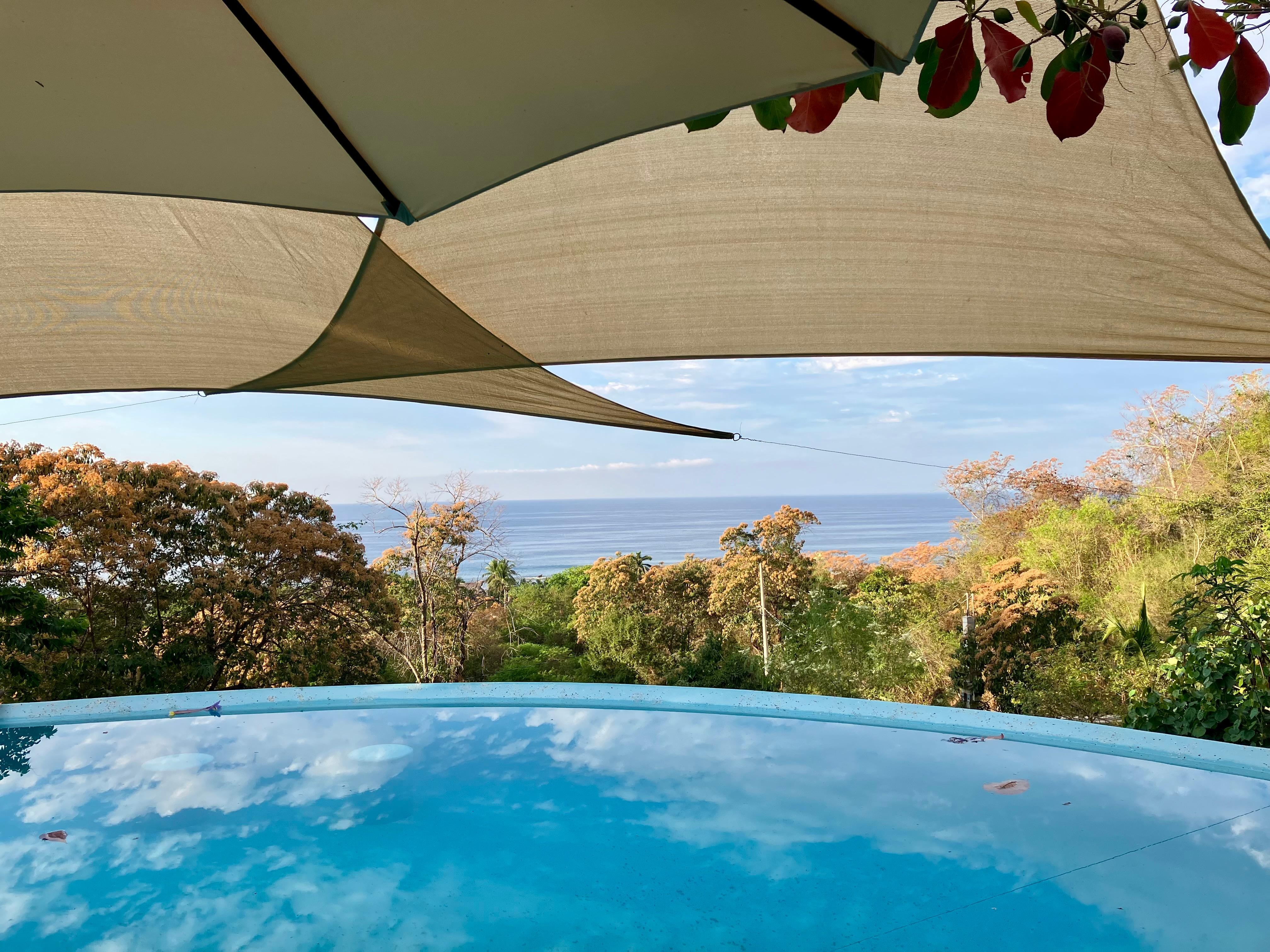 View from patio looking across pool  towards beach and ocean.