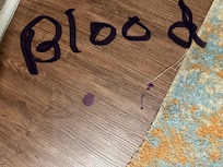 Spots of blood in the downstairs hallway