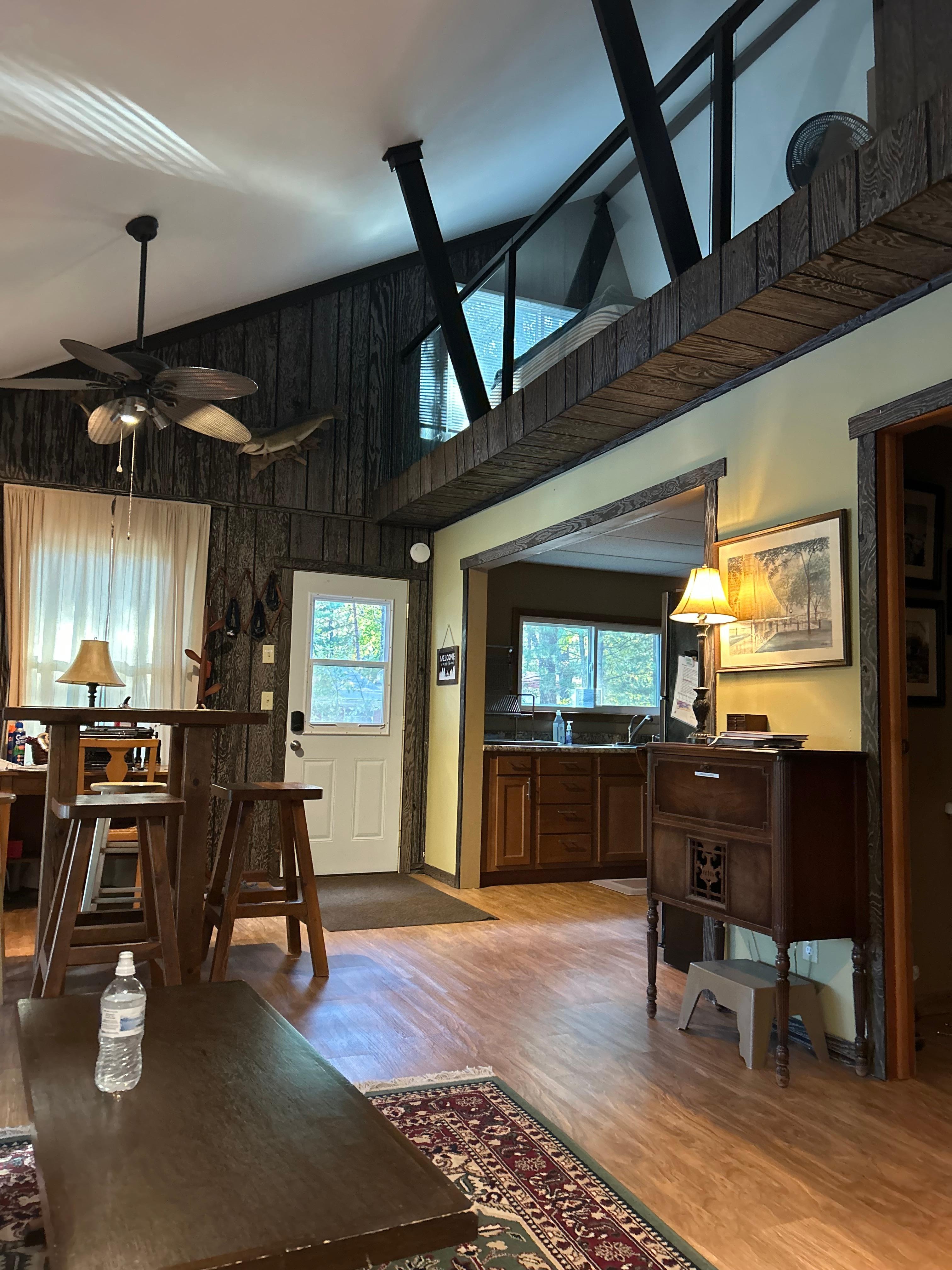 View from the living room showing the kitchen and the loft with the queen bed, top right 